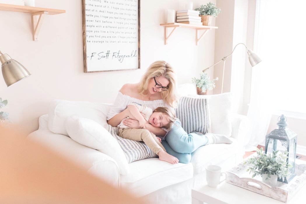 Mother sat on sofa cuddling child