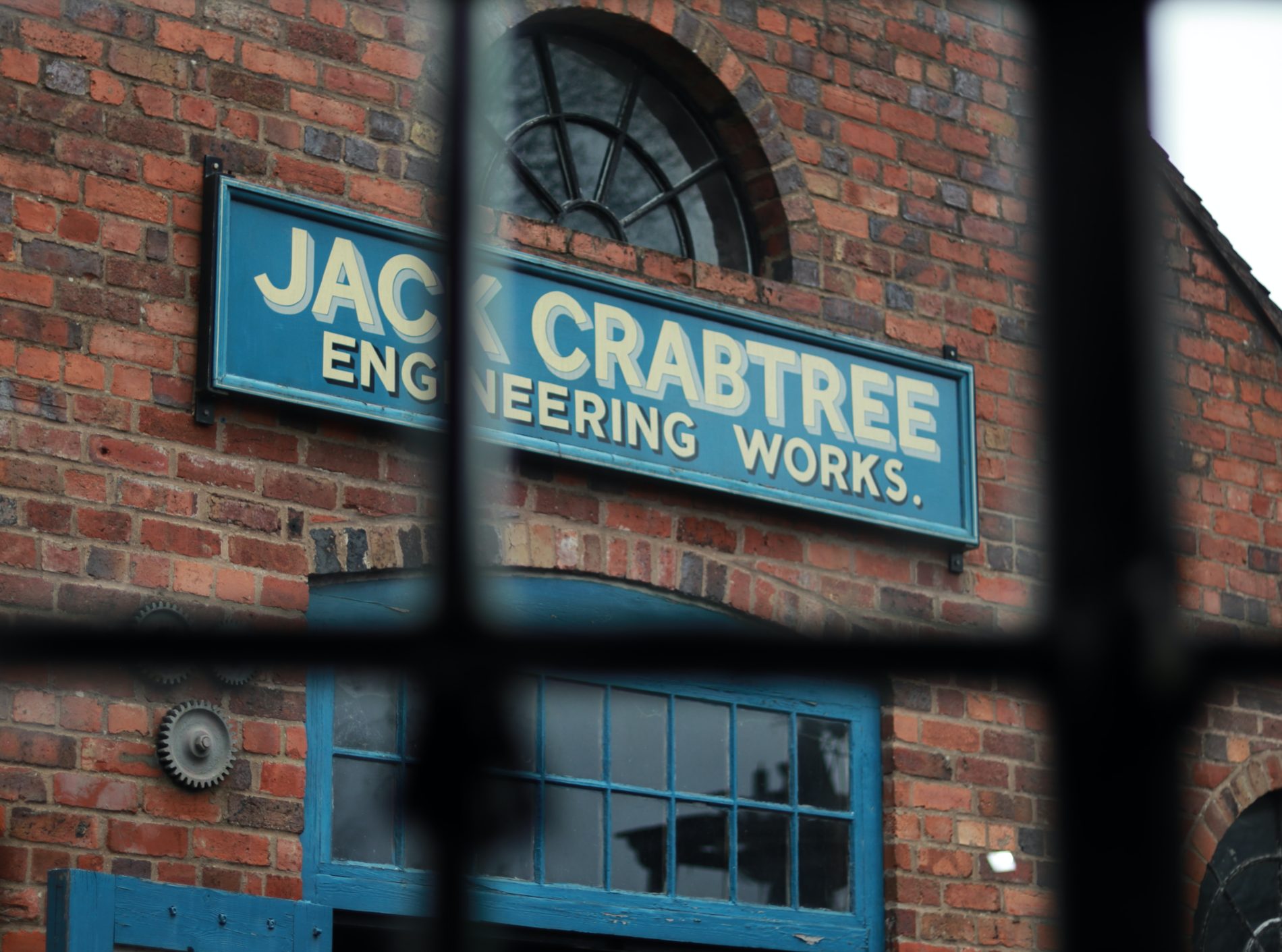 Image of an old engineering works building. Brick building with a blue sign.